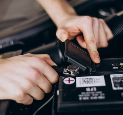 A car battery tester being used to check the voltage of a car battery