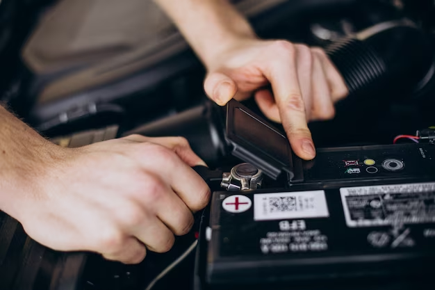 A car battery tester being used to check the voltage of a car battery